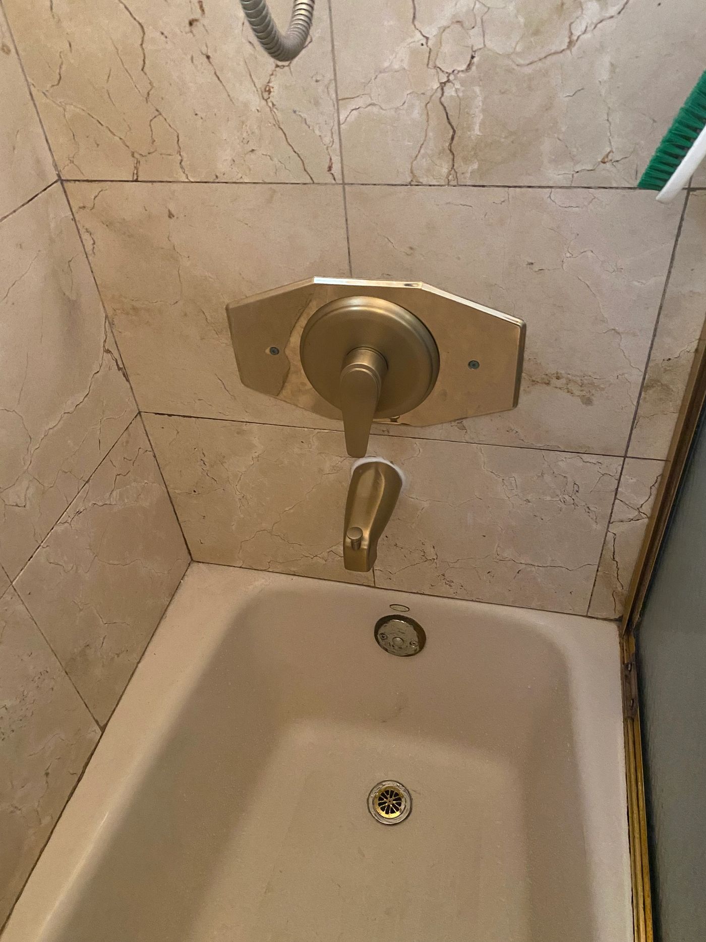 A shower valve and bath fixtures installed in a tiled bathroom