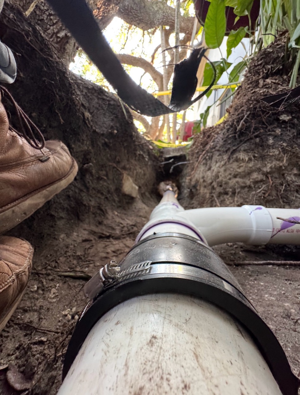 Underground PVC pipework and a coupling installed in an excavated trench